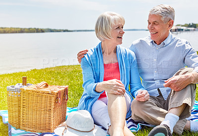 Buy stock photo Shot of a happy senior couple having a picnic together outside