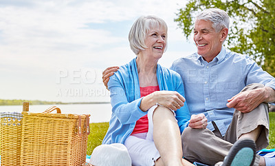 Buy stock photo Shot of a happy senior couple having a picnic together outside