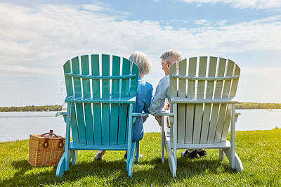 Buy stock photo Shot of an affectionate senior couple relaxing on chairs together outside