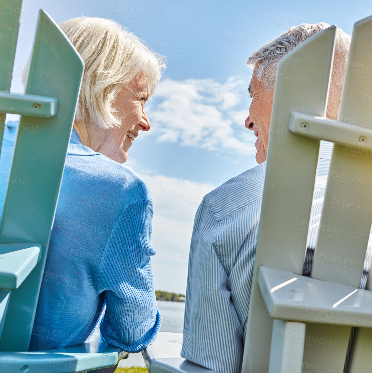 Buy stock photo Shot of an affectionate senior couple relaxing on chairs together outside