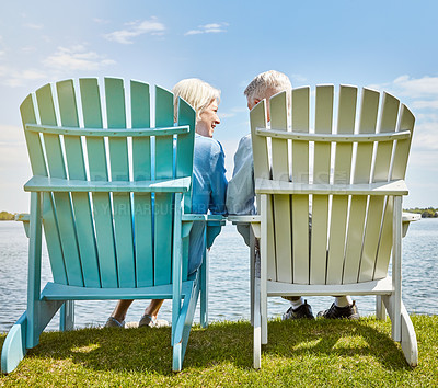 Buy stock photo Shot of an affectionate senior couple relaxing on chairs together outside