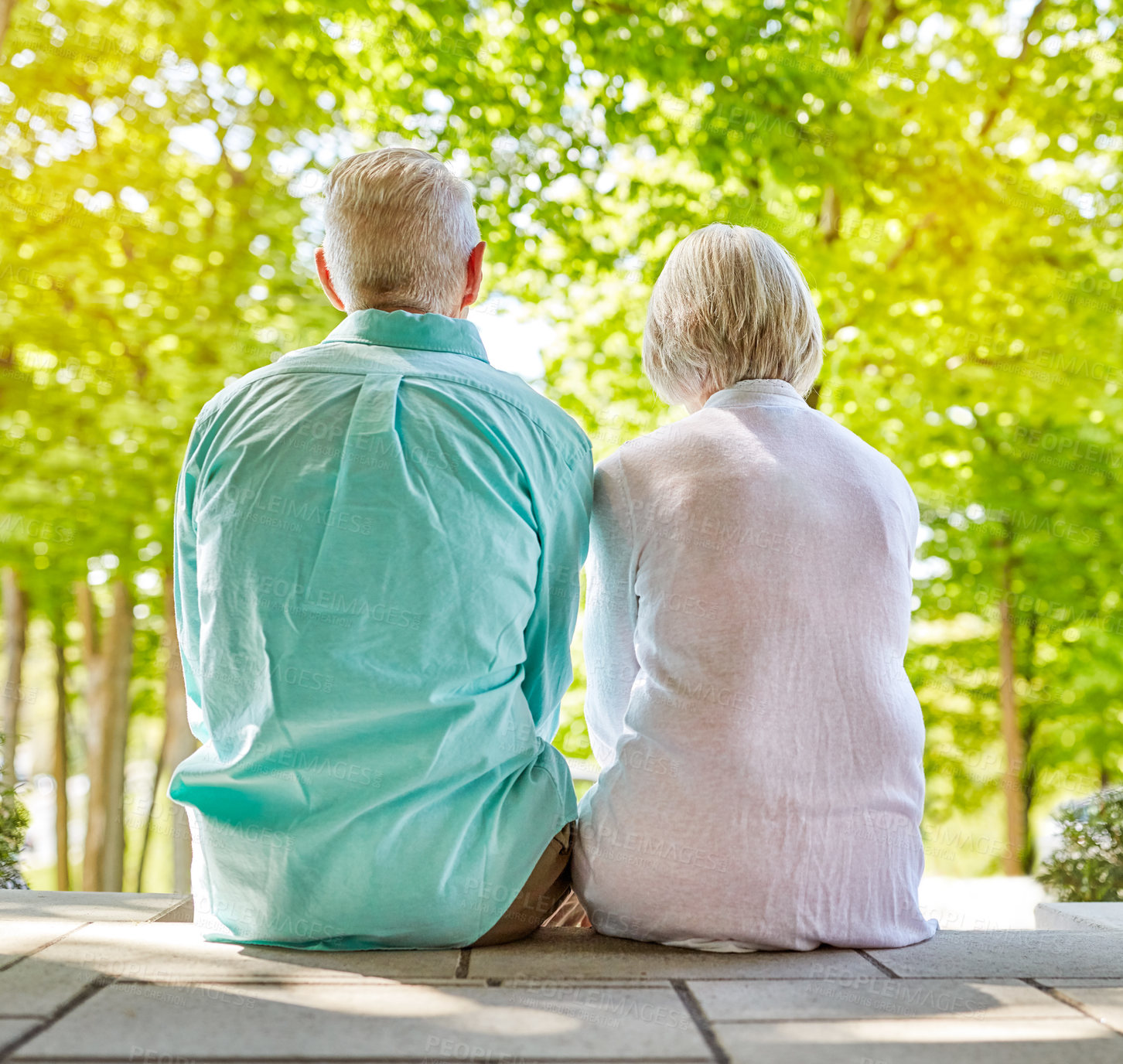 Buy stock photo Rearview shot of an affectionate senior couple sitting outside on their porch during the summer