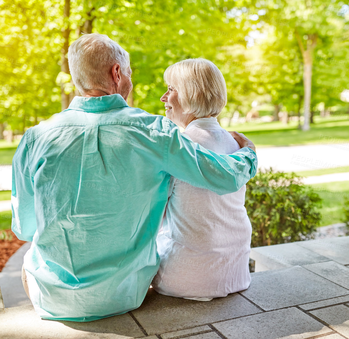 Buy stock photo Rearview shot of an affectionate senior couple sitting outside on their porch during the summer