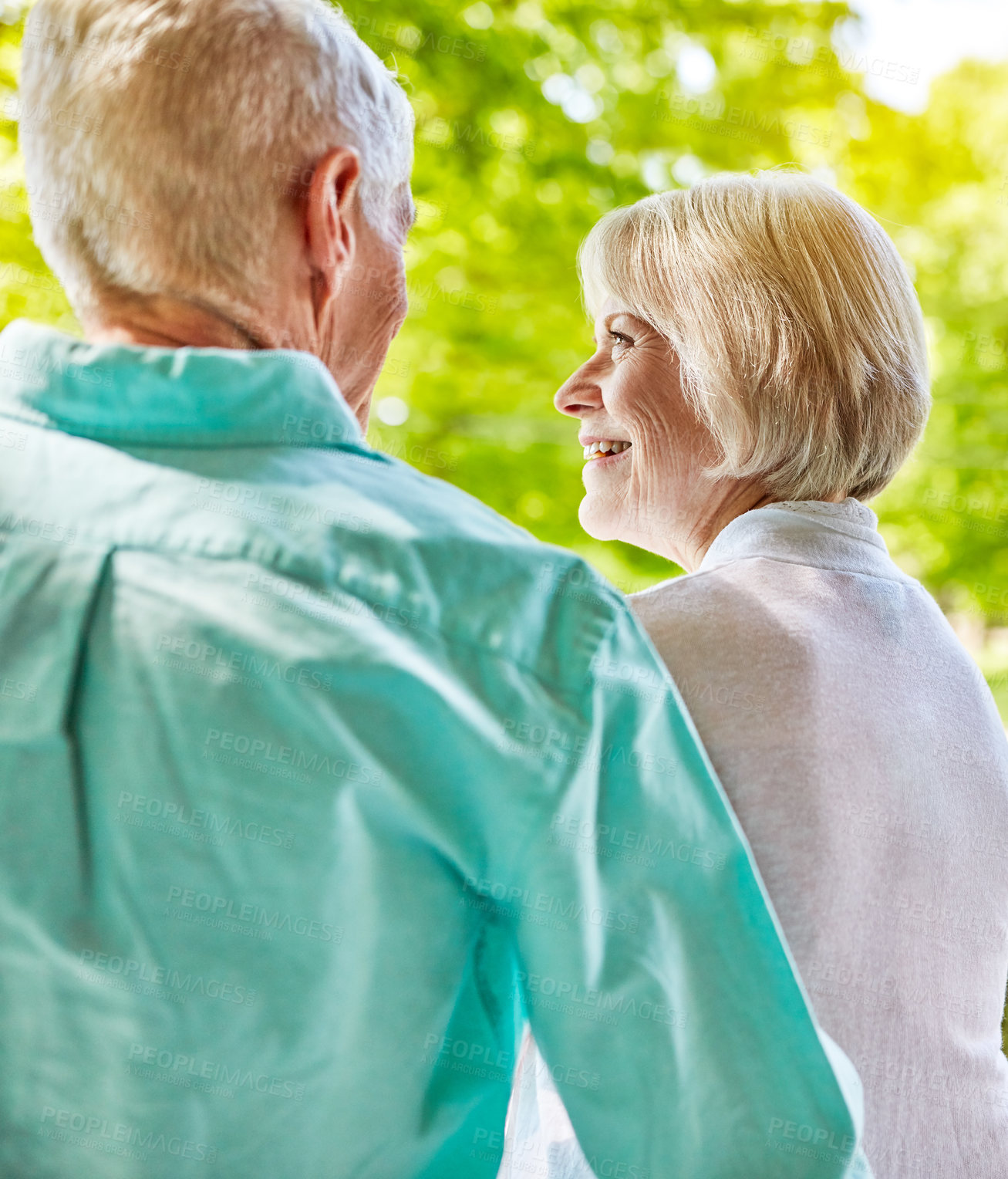 Buy stock photo Rearview shot of an affectionate senior couple sitting outside on their porch during the summer