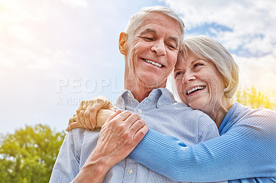 Buy stock photo Shot of a happy senior couple in a loving embrace outside