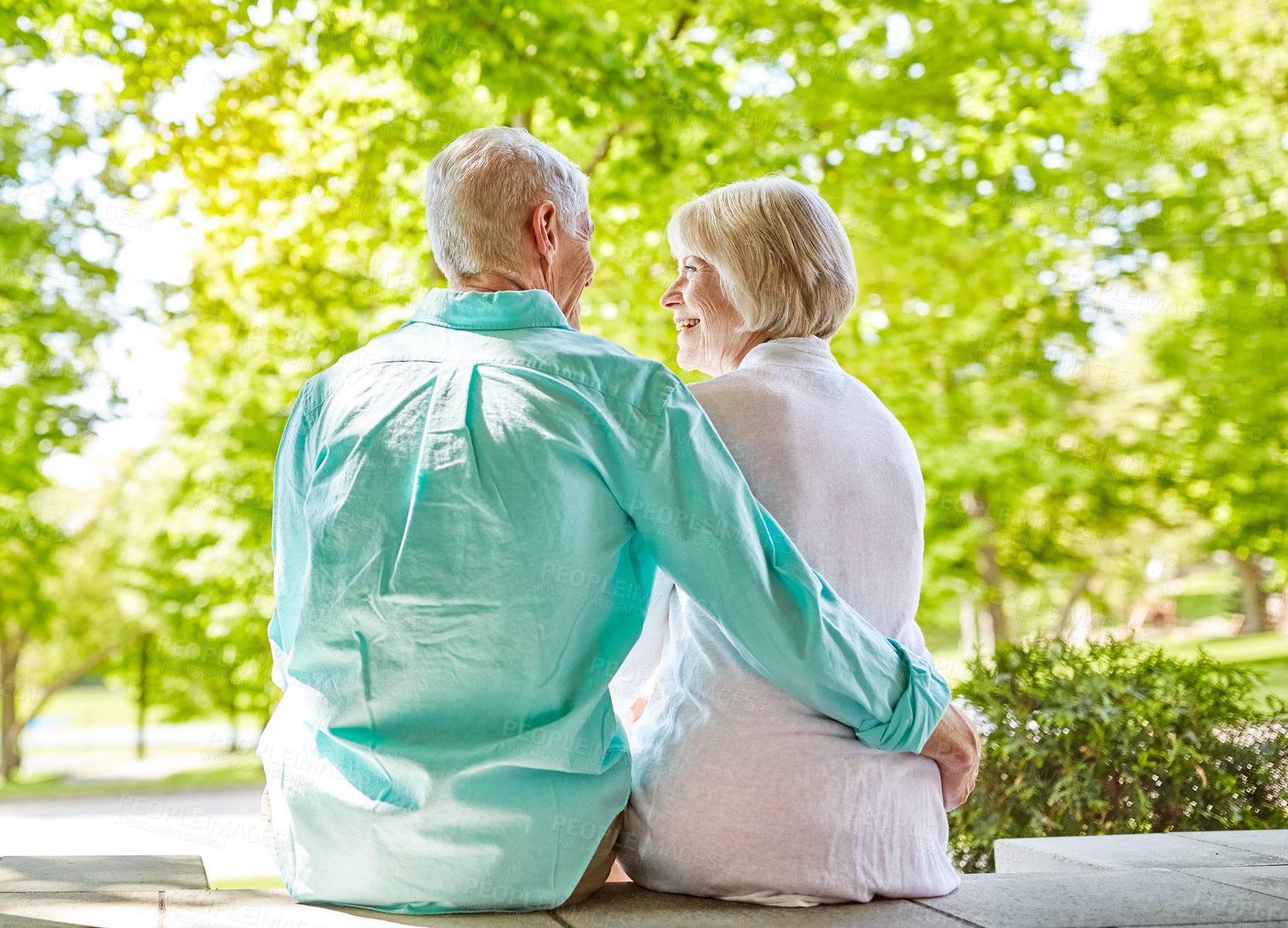 Buy stock photo Rearview shot of an affectionate senior couple sitting outside on their porch during the summer