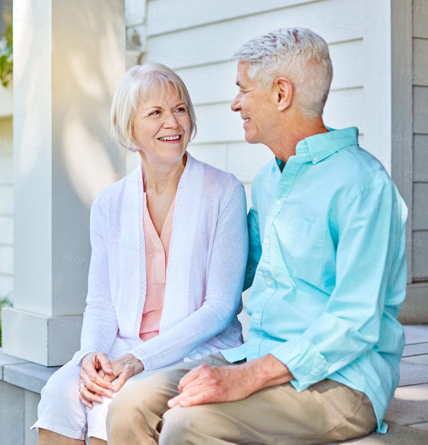 Buy stock photo Cropped shot of an affectionate senior couple sitting outside on their porch during the summer