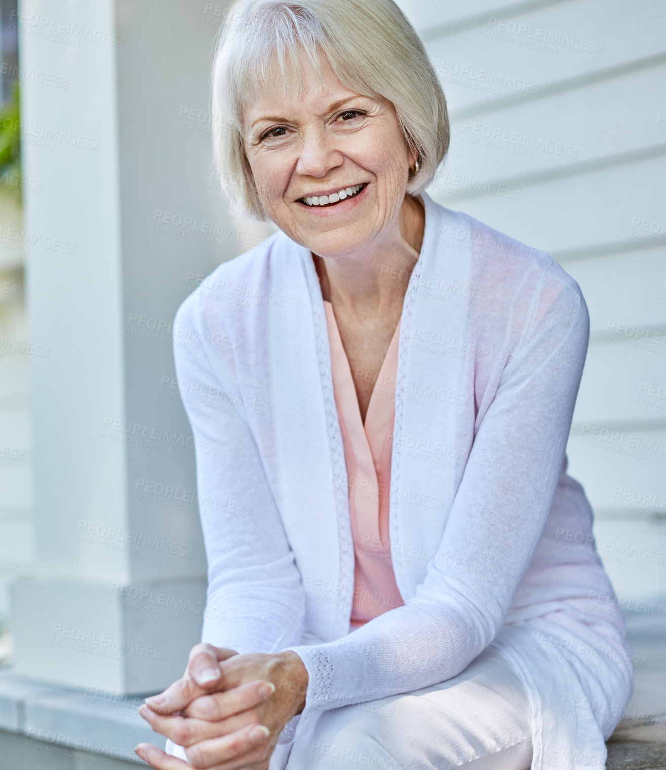 Buy stock photo Cropped portrait of a senior woman sitting on her porch during the summer