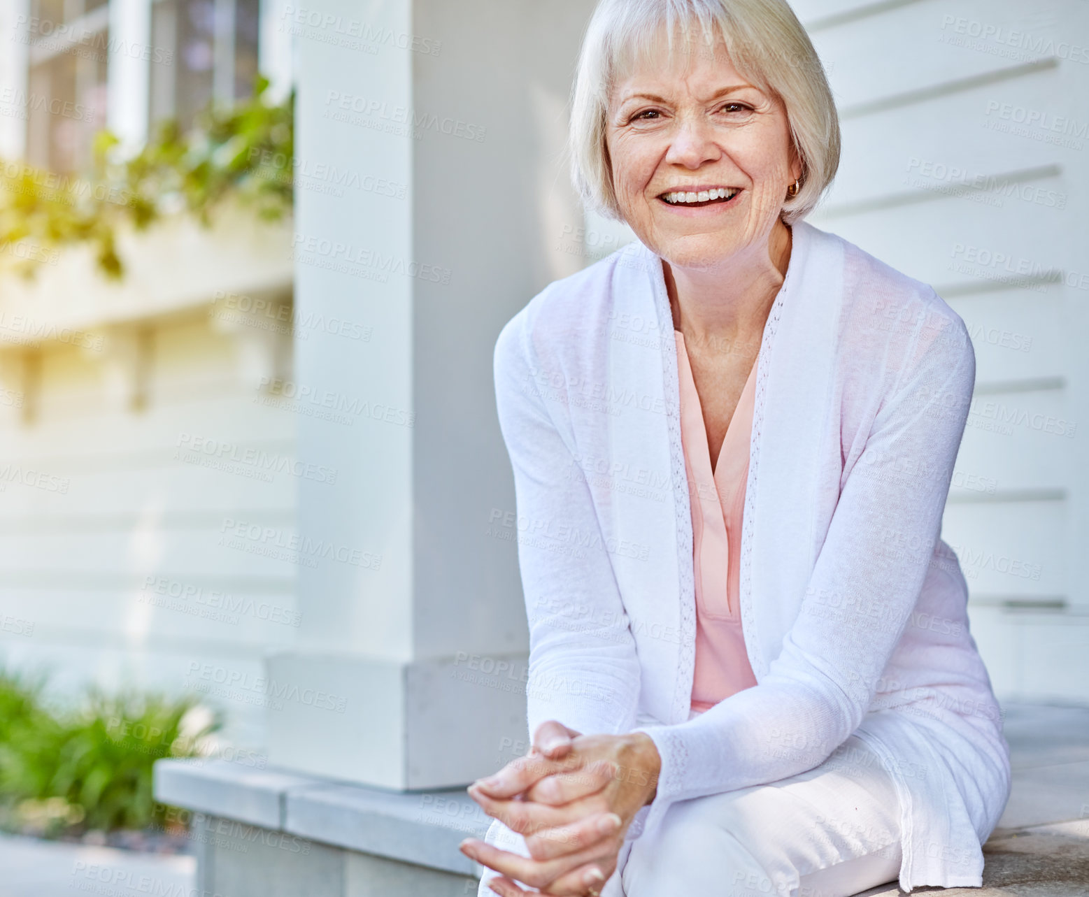 Buy stock photo Cropped portrait of a senior woman sitting on her porch during the summer