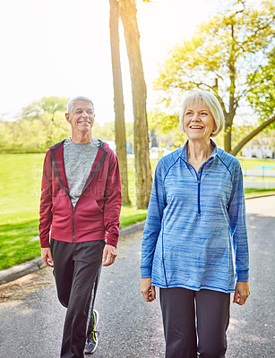 Buy stock photo Cropped shot of an affectionate senior couple taking a walk in the park during the summer