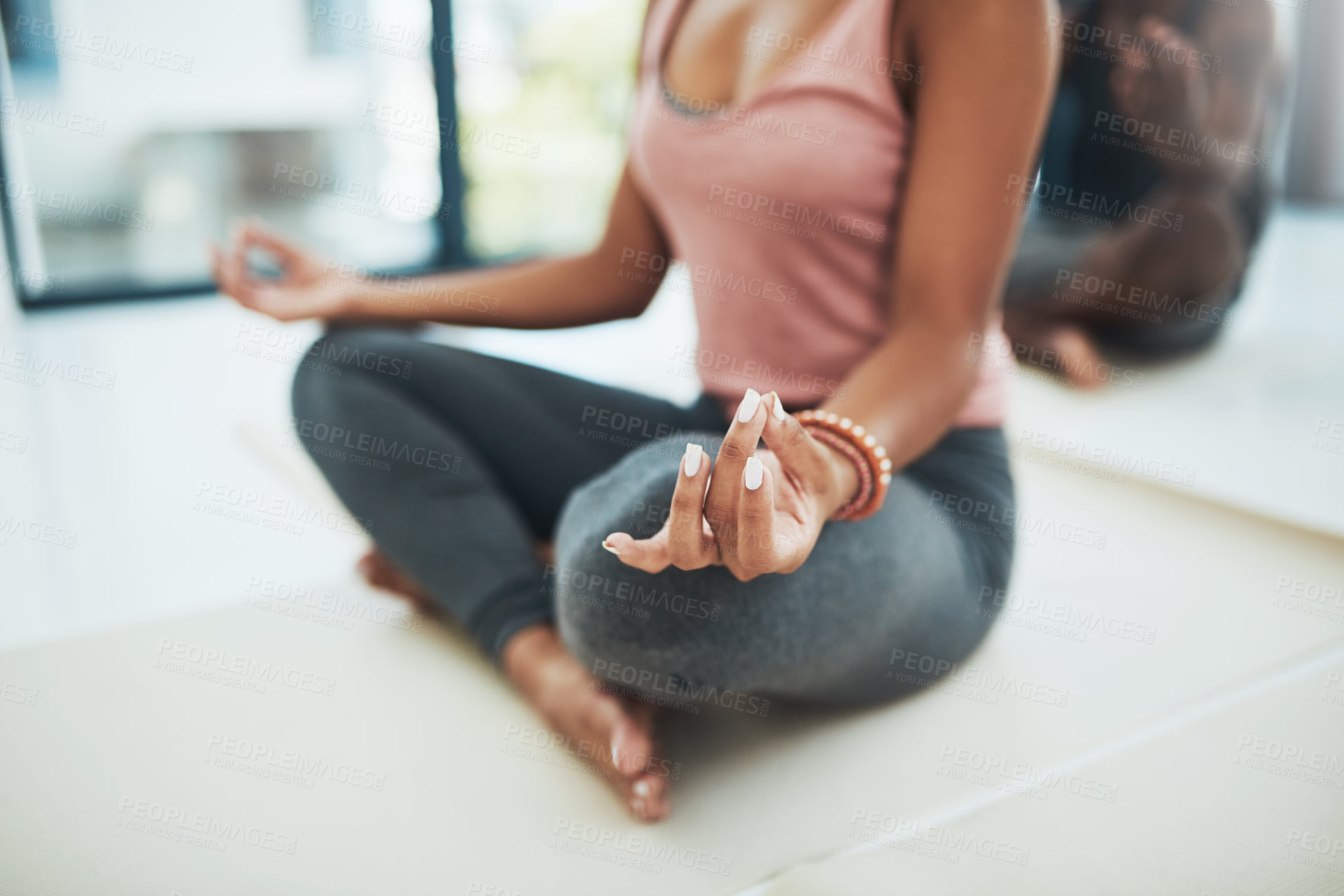 Buy stock photo Shot of a unrecognizable fit woman doing a yoga pose on the floor inside of a studio