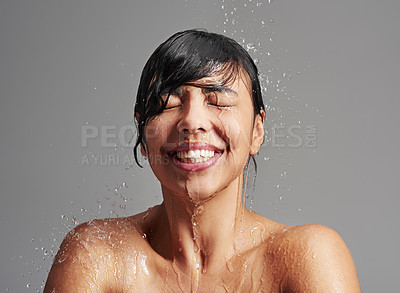 Buy stock photo Shower, water splash and face of woman in studio on gray background for wellness, cleaning and grooming. Skincare, beauty mockup and female person with smile for washing hair, body and cleansing