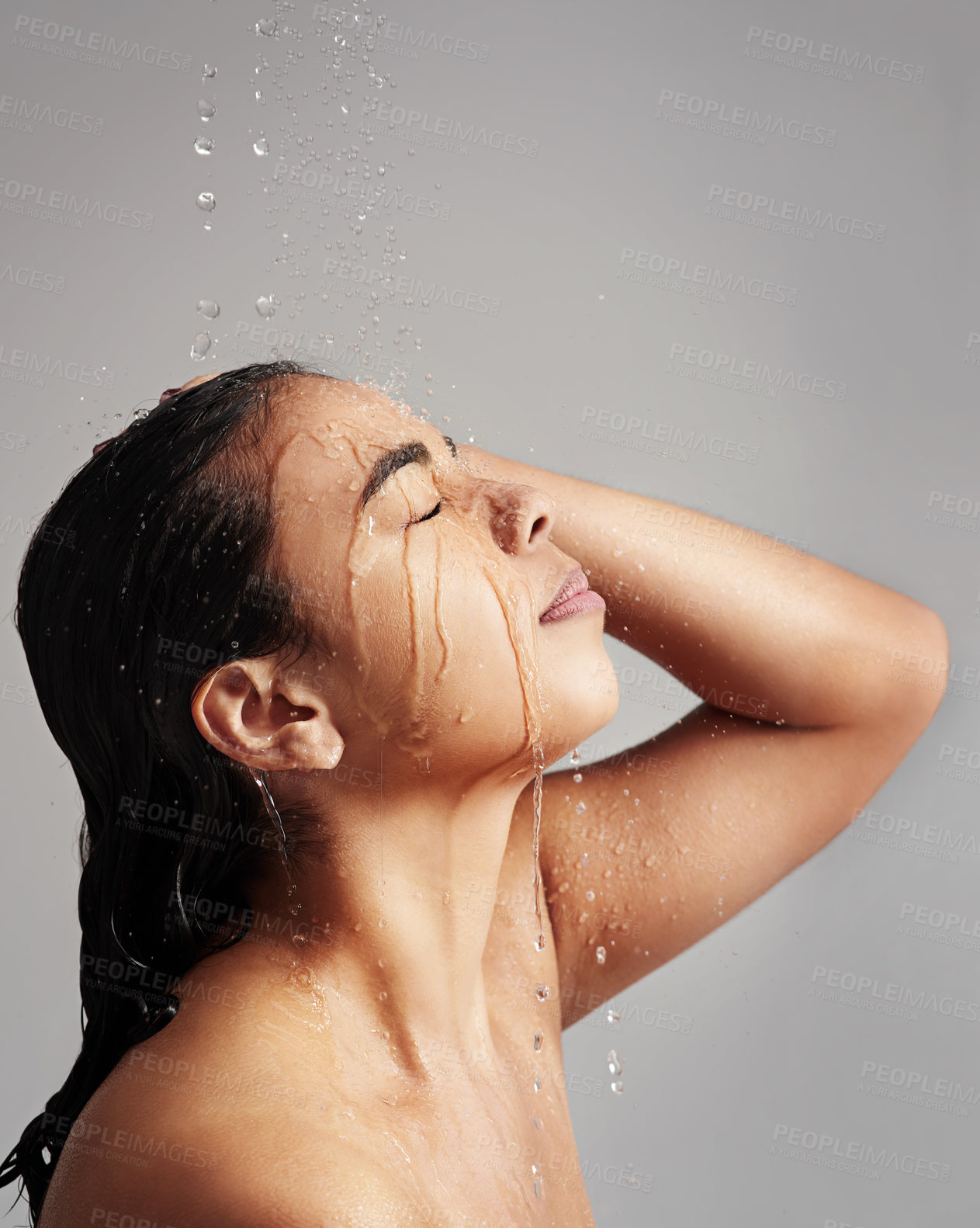 Buy stock photo Water splash, shower and face of woman in studio on gray background for wellness, cleaning and grooming. Skincare, beauty mockup and profile of female person for washing hair, self care and cleansing
