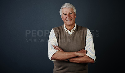 Buy stock photo Studio portrait of a handsome mature man posing with his arms crossed against a dark background