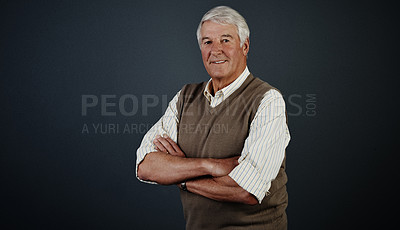 Buy stock photo Studio portrait of a handsome mature man posing with his arms crossed against a dark background