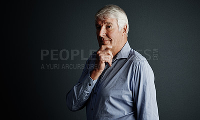 Buy stock photo Studio shot of a handsome mature man looking thoughtful against a dark background