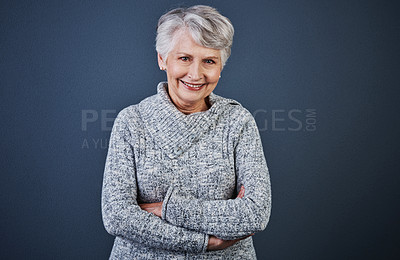 Buy stock photo Studio shot of a cheerful elderly woman standing with her arms folded while looking  at the camera