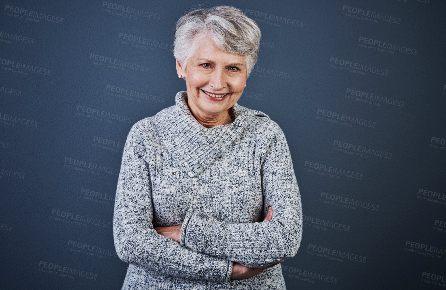 Buy stock photo Studio shot of a cheerful elderly woman standing with her arms folded while looking  at the camera