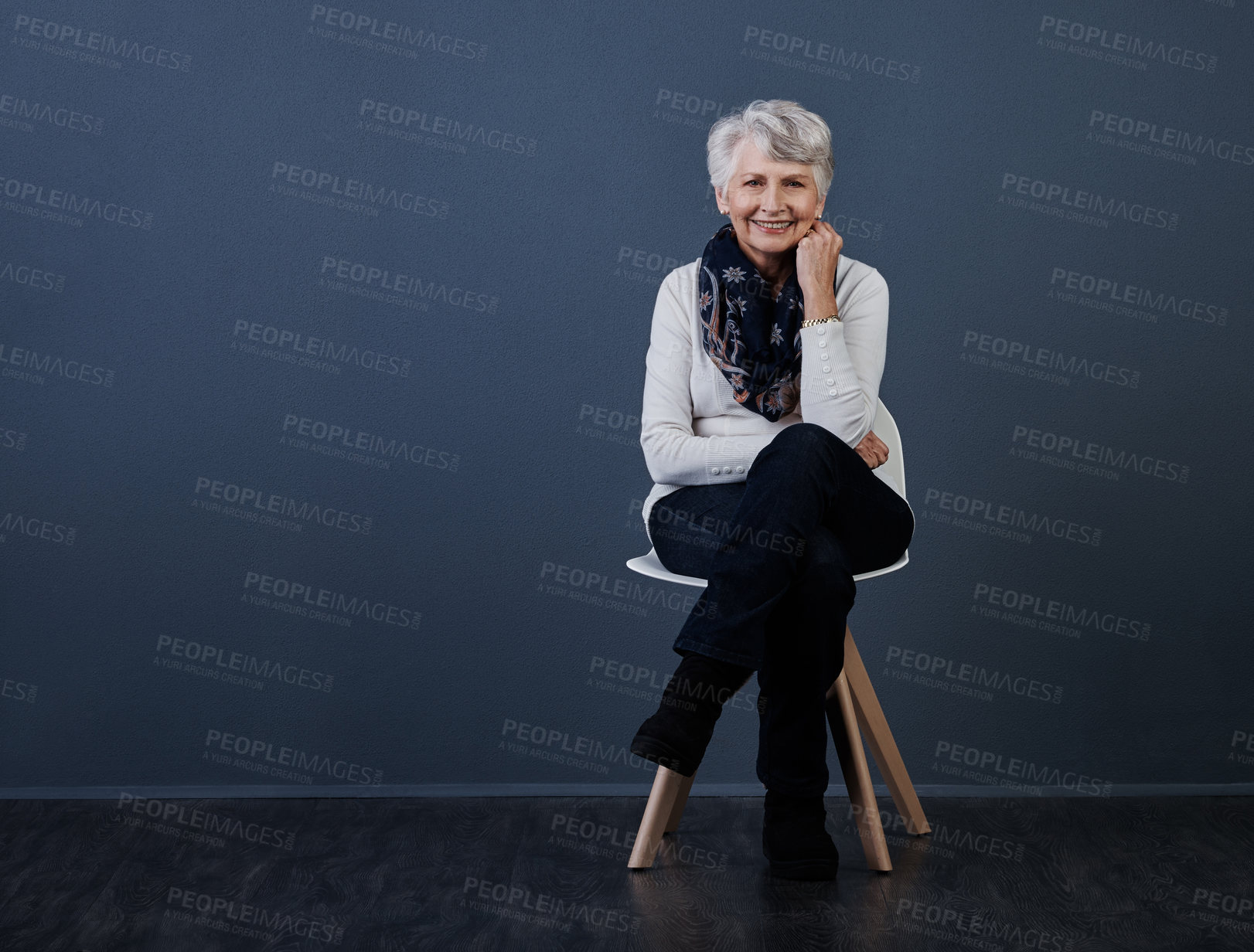 Buy stock photo Elderly woman, happy and fashion in studio portrait on chair, pride and mockup space on gray background. Senior person, smile and confident with jersey, clothes and relax with retirement in Australia
