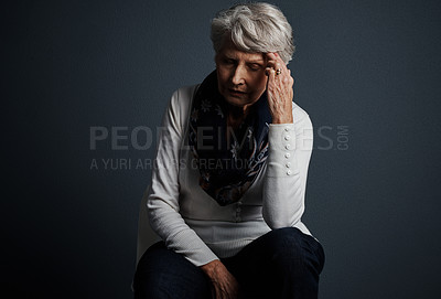 Buy stock photo Studio shot of a stressed out elderly woman sitting down with her eyes closed and contemplating