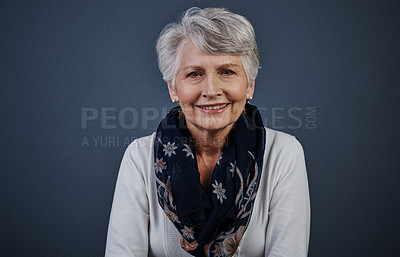 Buy stock photo Studio shot of a cheerful elderly woman sitting down and looking straight into the camera while smiling