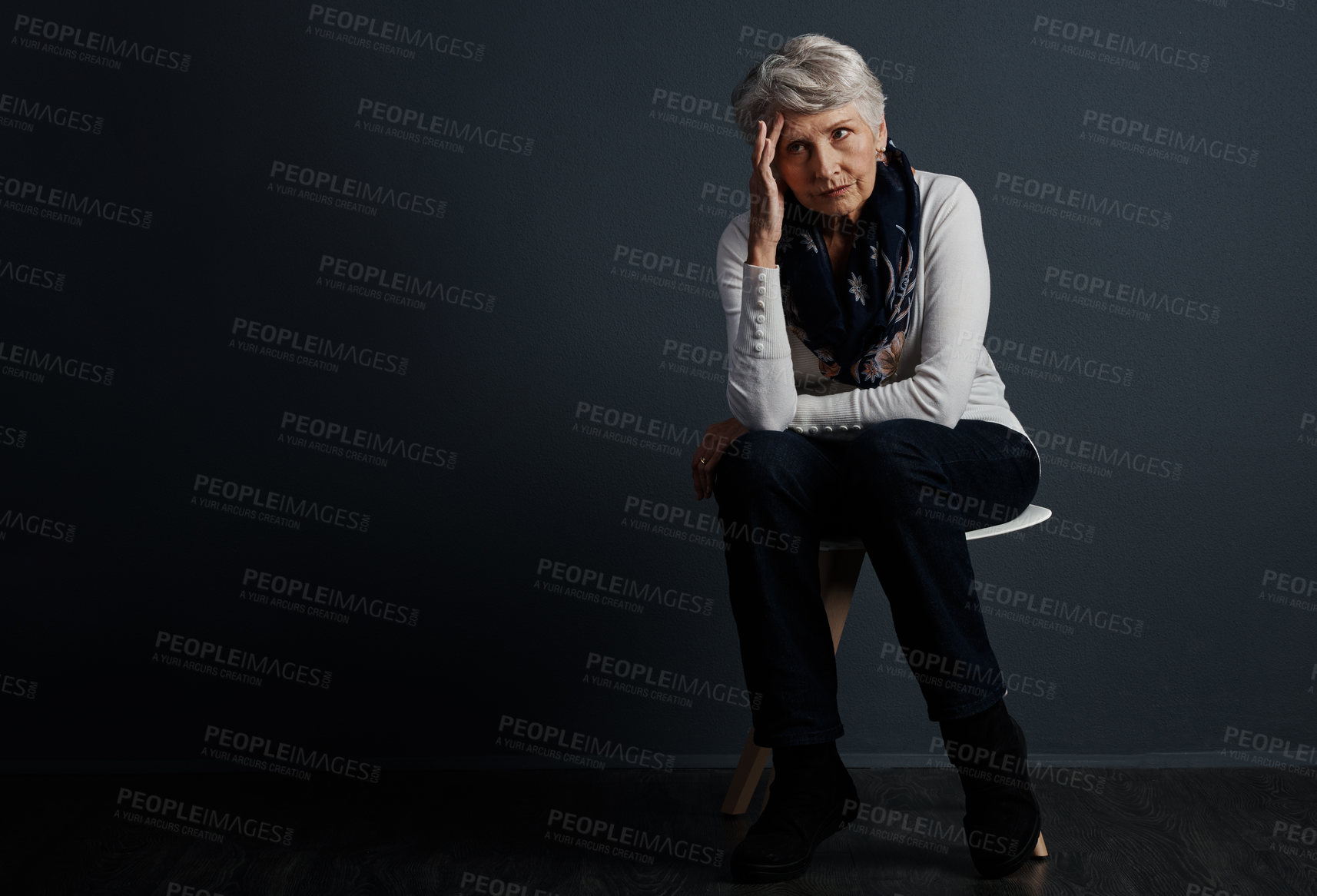 Buy stock photo Studio shot of a stressed out elderly woman sitting down and contemplating while looking into the distance