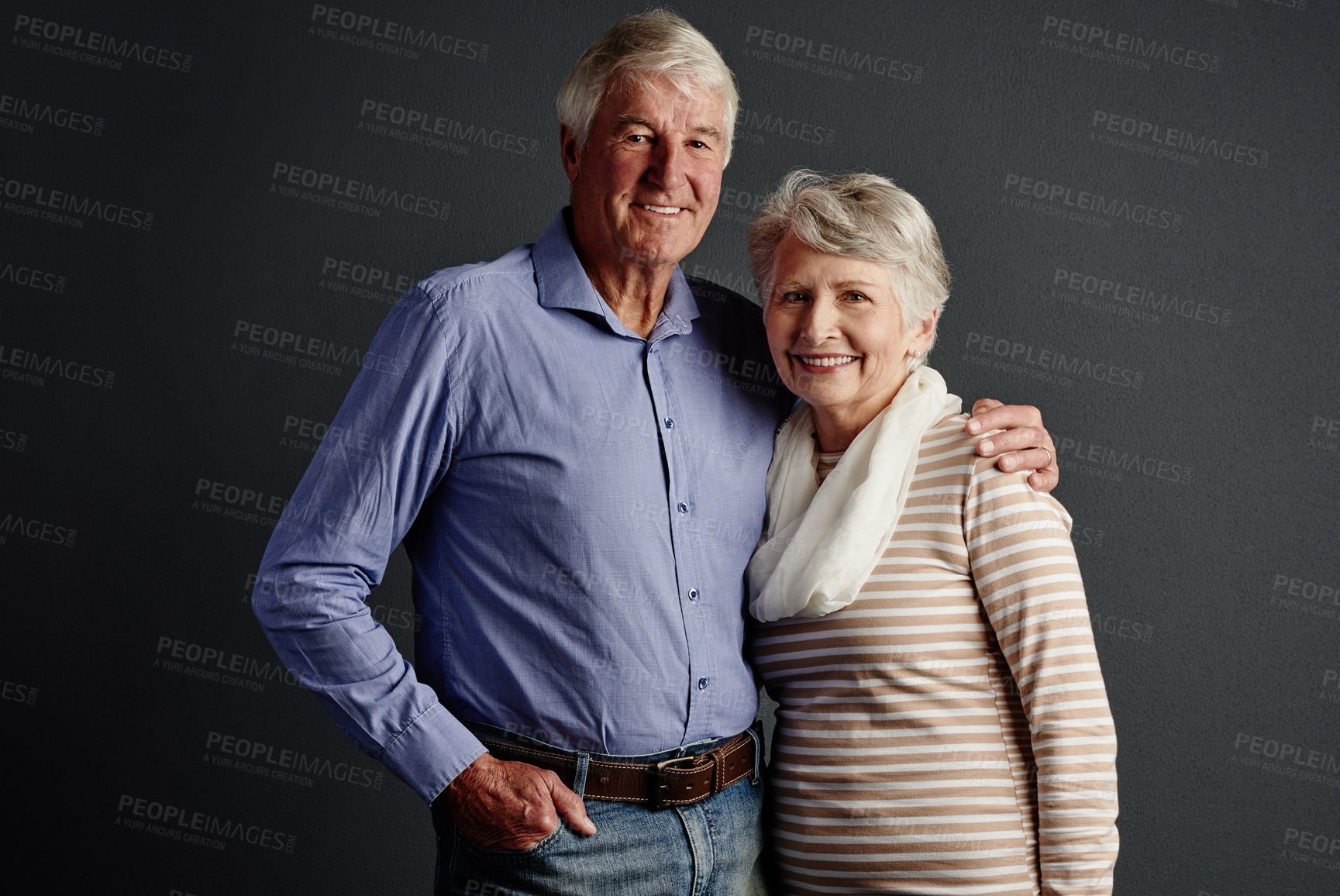 Buy stock photo Studio portrait of an affectionate senior couple posing against a grey background