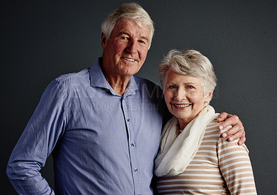 Buy stock photo Studio portrait of an affectionate senior couple posing against a grey background