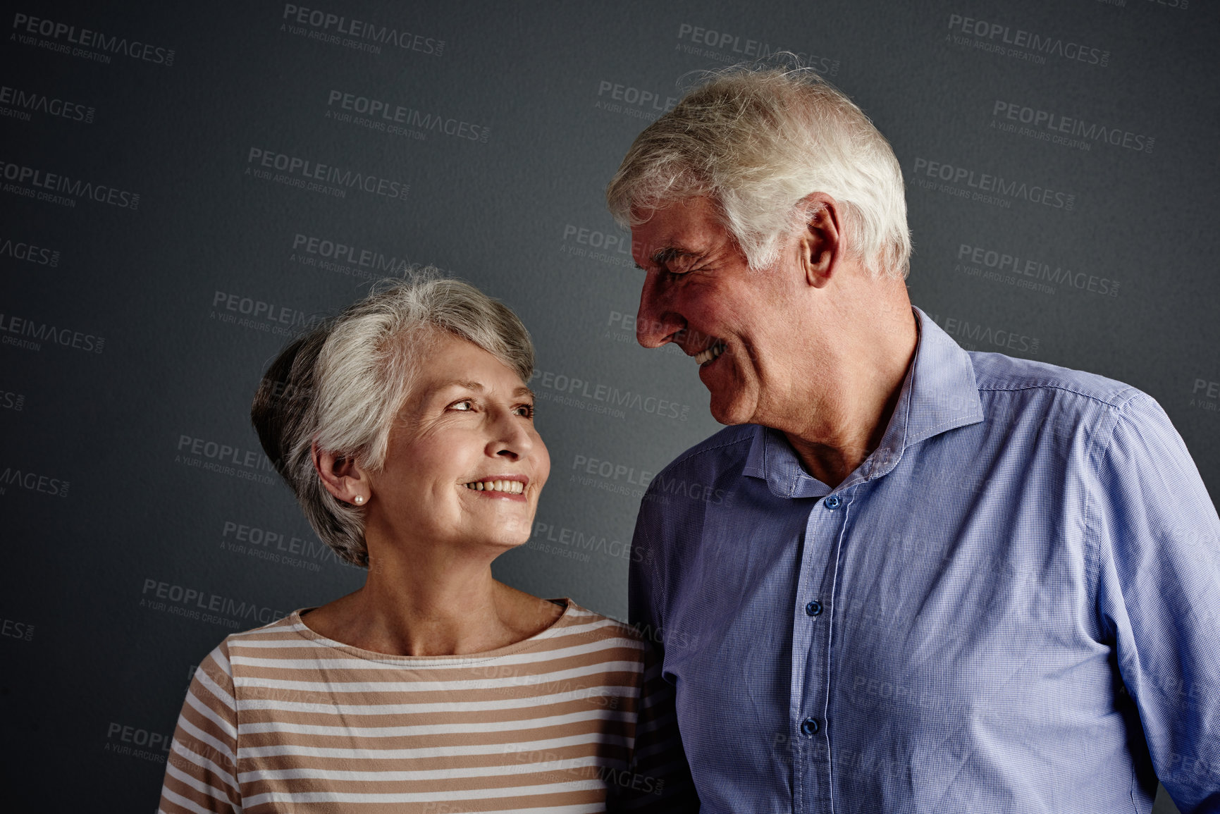 Buy stock photo Studio shot of an affectionate senior couple posing against a grey background