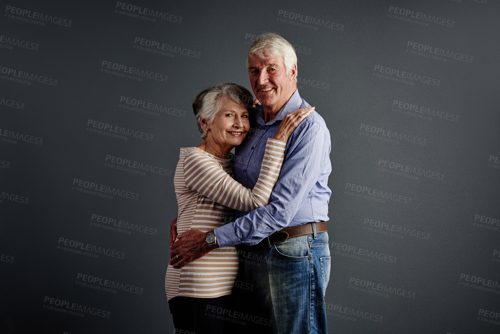 Buy stock photo Studio portrait of an affectionate senior couple posing against a grey background