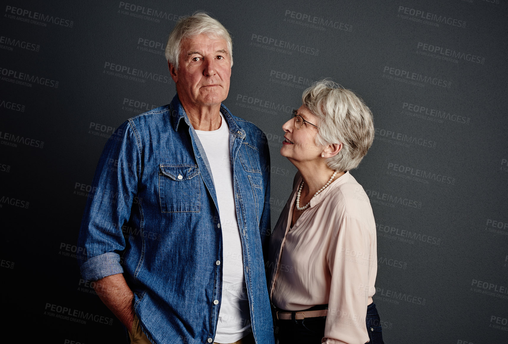 Buy stock photo Studio portrait of an affectionate senior couple posing against a grey background