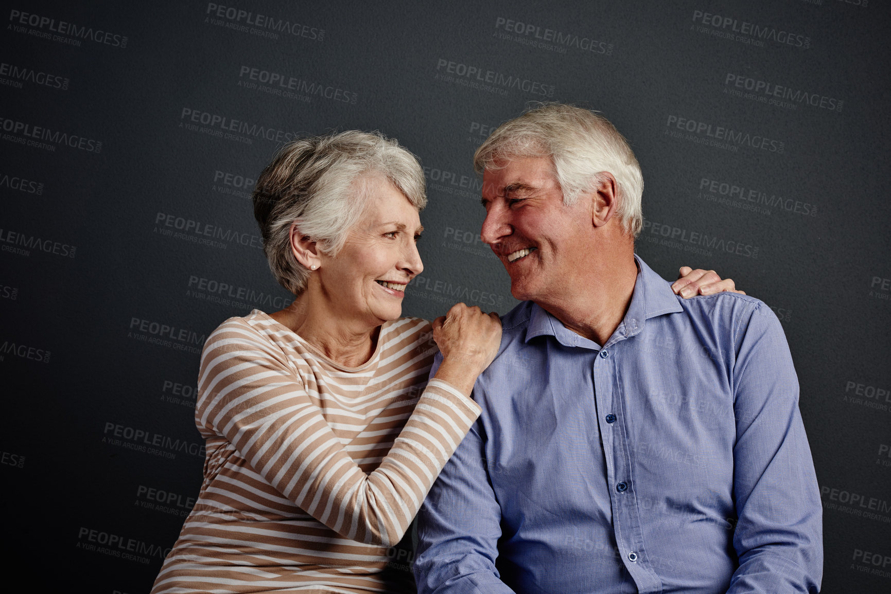 Buy stock photo Studio shot of an affectionate senior couple posing against a grey background