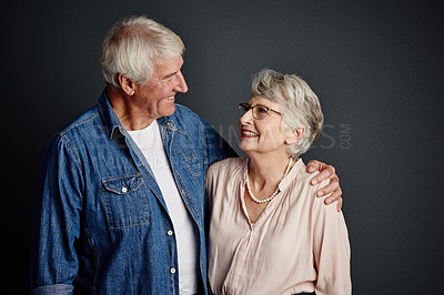 Buy stock photo Studio shot of an affectionate senior couple posing against a grey background
