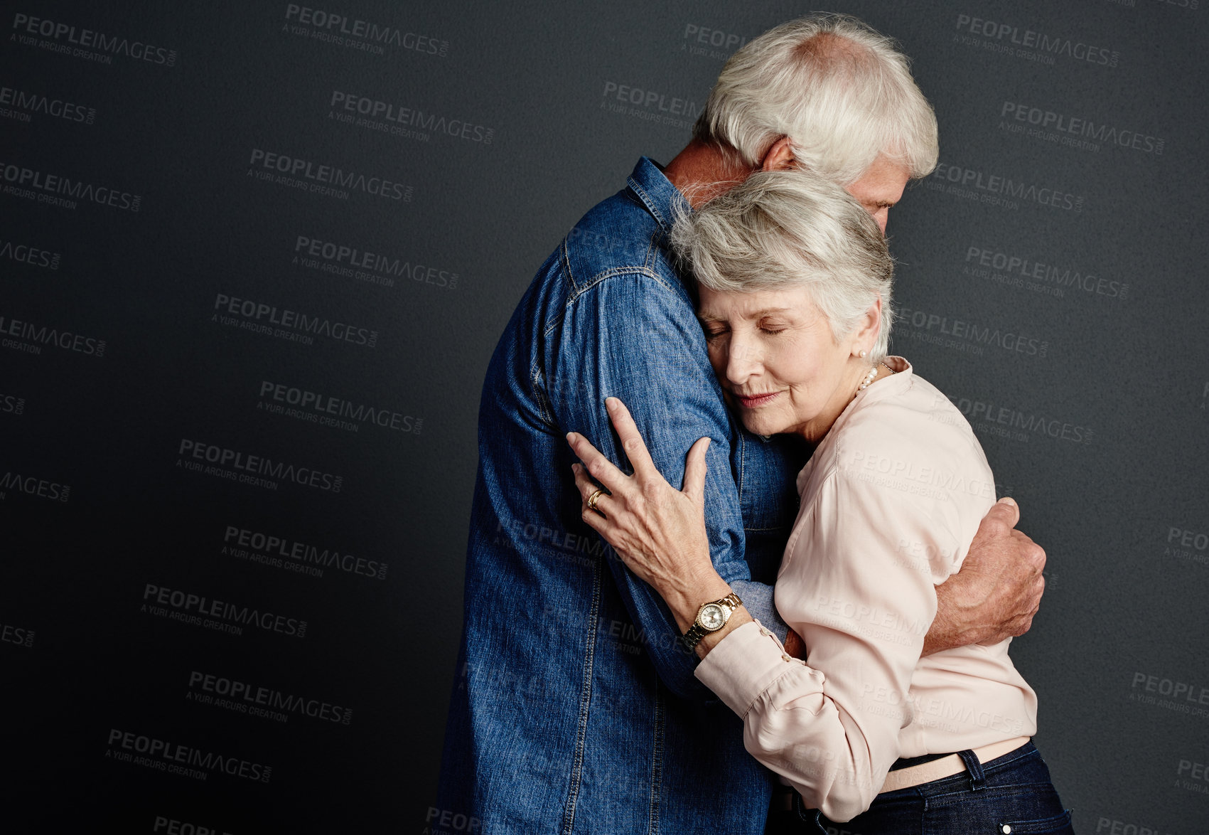 Buy stock photo Studio shot of an affectionate senior couple posing against a grey background