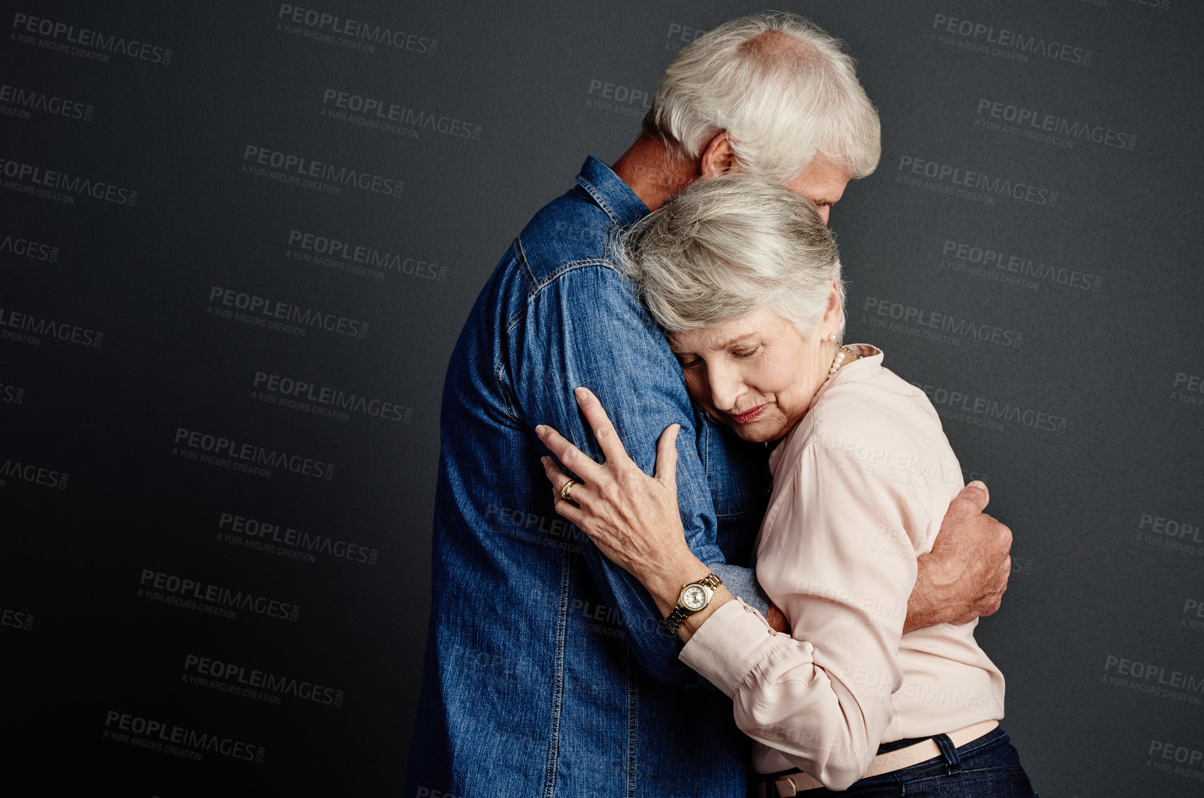 Buy stock photo Studio shot of an affectionate senior couple posing against a grey background