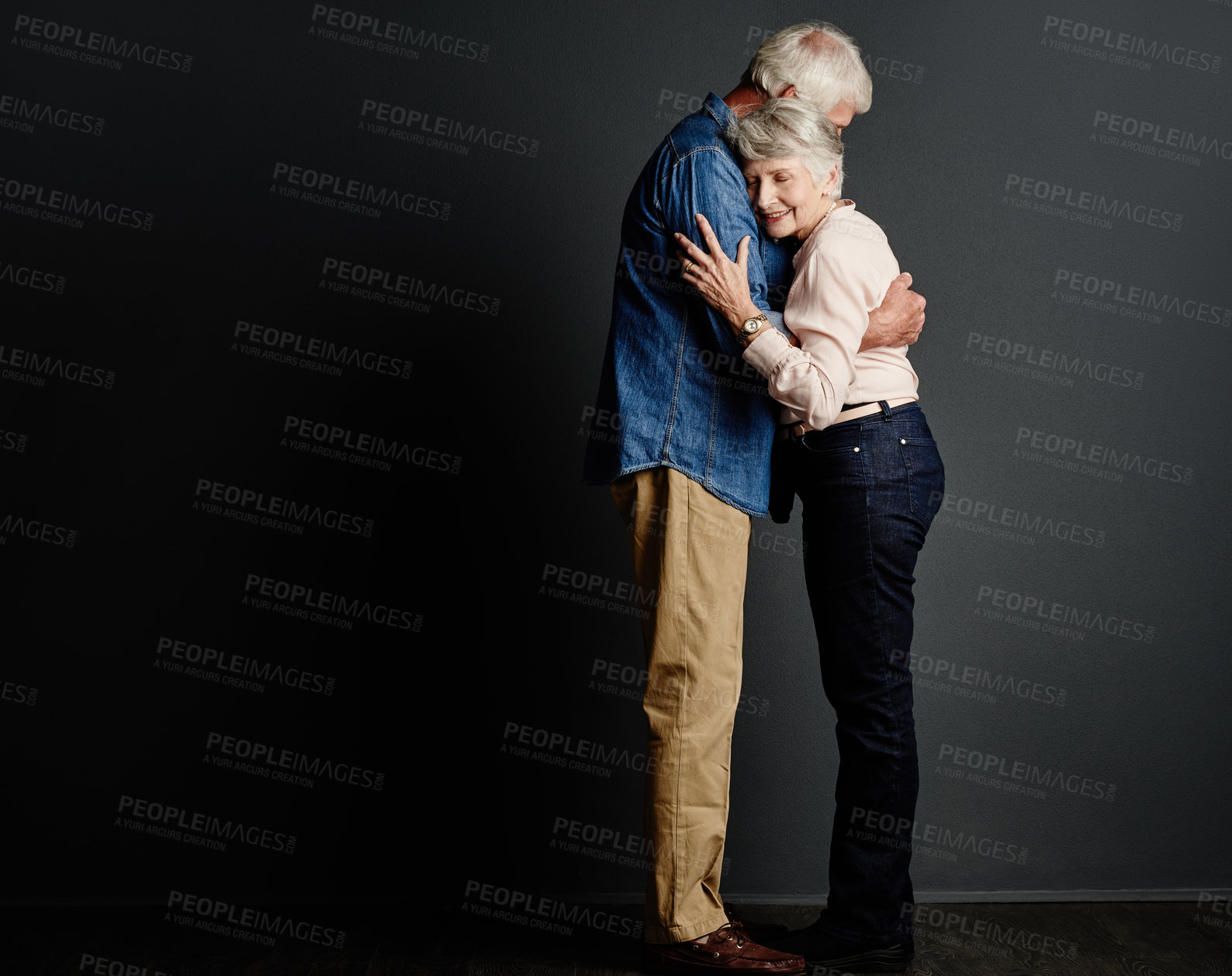 Buy stock photo Studio shot of an affectionate senior couple posing against a grey background