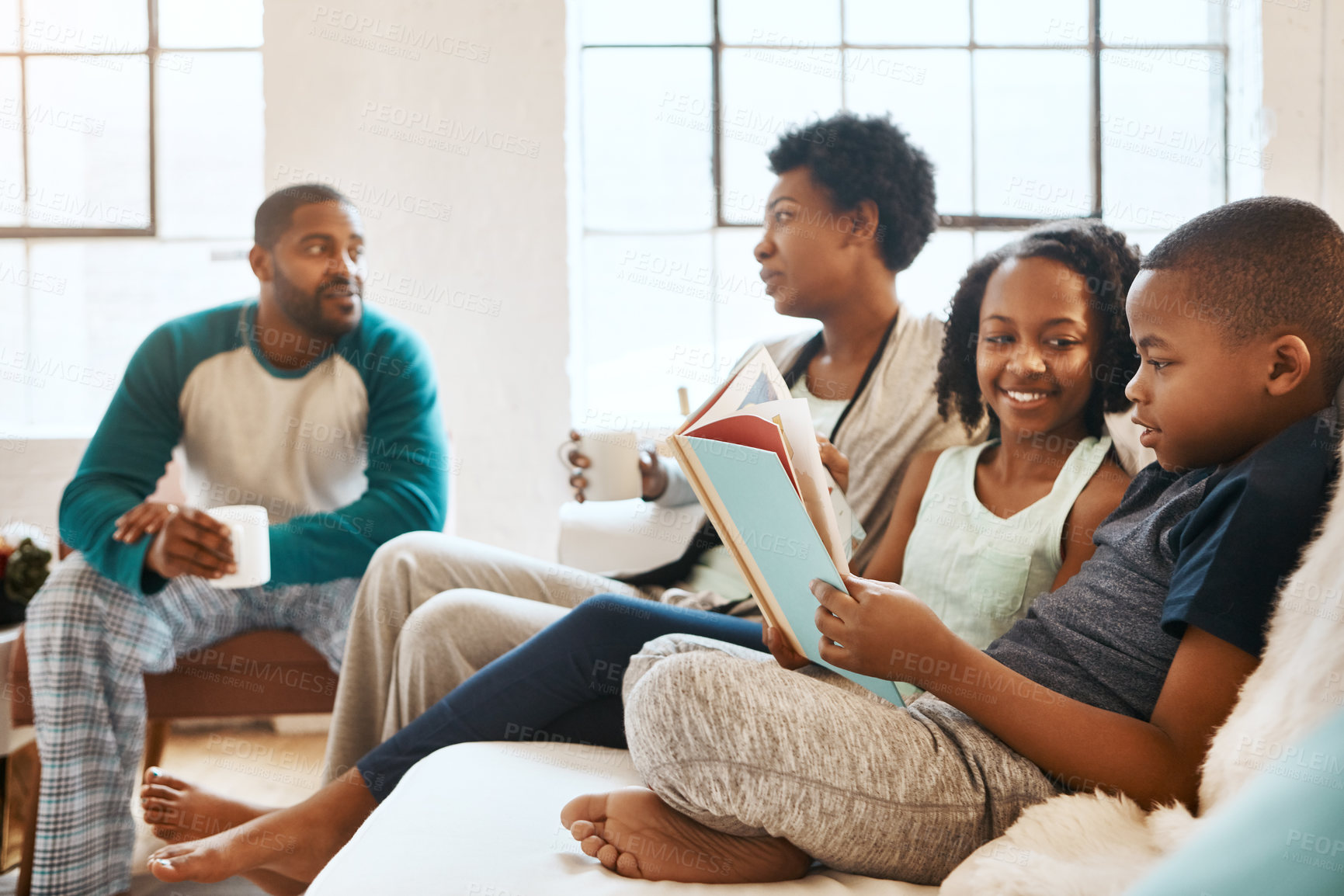 Buy stock photo Black family, reading book and kids on sofa in home, care and learning for language in living room. African parents, children and storytelling for connection, bonding and relax in pajamas in morning