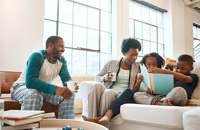Buy stock photo Shot of a little brother and sister reading a book while their parents watch at home