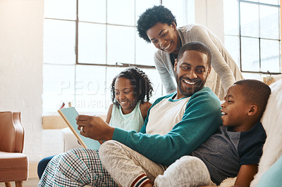 Buy stock photo Shot of a family reading a book indoors