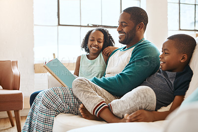 Buy stock photo Shot of a family reading a book indoors 