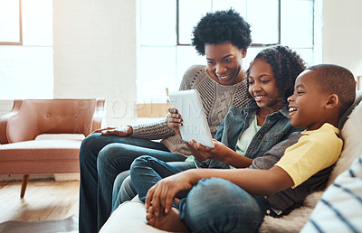 Buy stock photo Shot a mother and her children sitting on the sofa using a tablet indoors