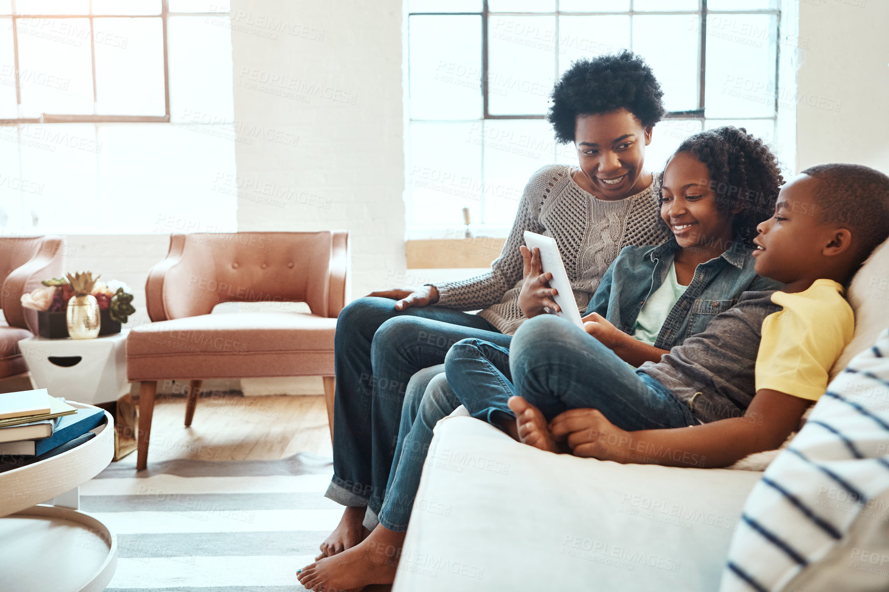 Buy stock photo Shot a mother and her children sitting on the sofa using a tablet indoors