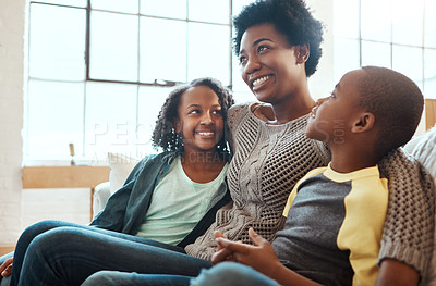 Buy stock photo Shot a mother and her children sitting on the sofa together indoors