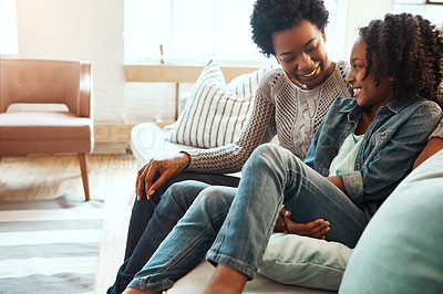 Buy stock photo Shot a mother and her daughter sitting on the sofa together indoors