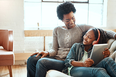 Buy stock photo Shot of a mother and her daughter using a tablet indoors