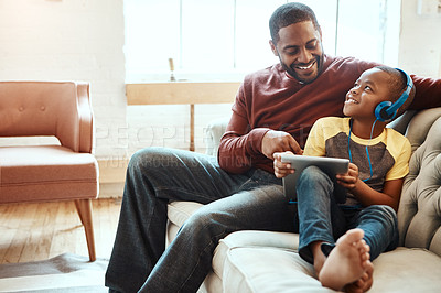Buy stock photo Digital tablet, father and boy on a sofa watching a funny, comic or meme video on social media. Happy, smile and African man streaming a movie with his child on mobile device while relaxing together.