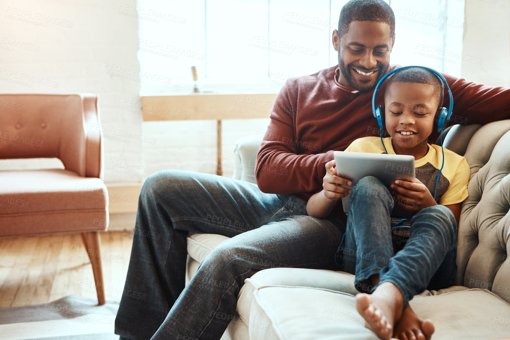 Buy stock photo Shot of a father and son using a tablet indoors