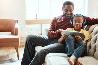 Buy stock photo Tablet, sofa and father with his son watching a funny, comic or meme video on social media. Happy, smile and African man streaming a movie with his boy child on mobile device while relaxing together.