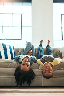 Buy stock photo Black children, siblings and relax on living room sofa lying upside down with smile for fun time together at home. Happy African American kids relaxing, playing and smiling on couch at the house
