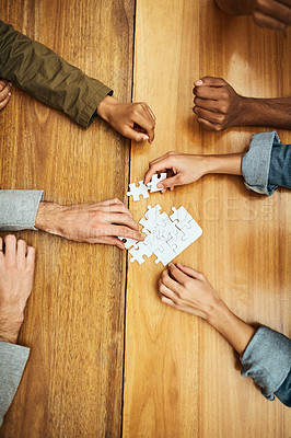 Buy stock photo High angle shot of a group of unrecognizable university students building a puzzle while studying in the library